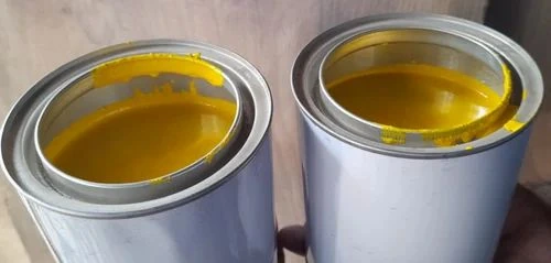 Open containers of yellow printing ink