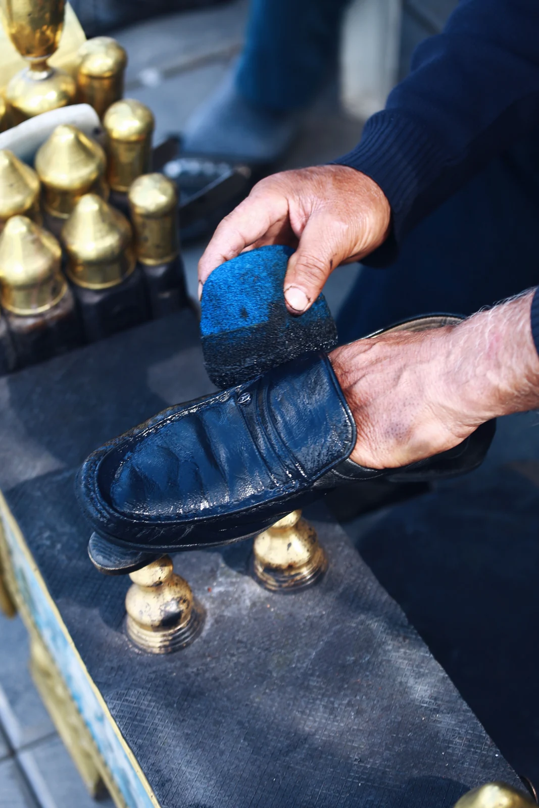 A leather shoe being cleaned with a brush