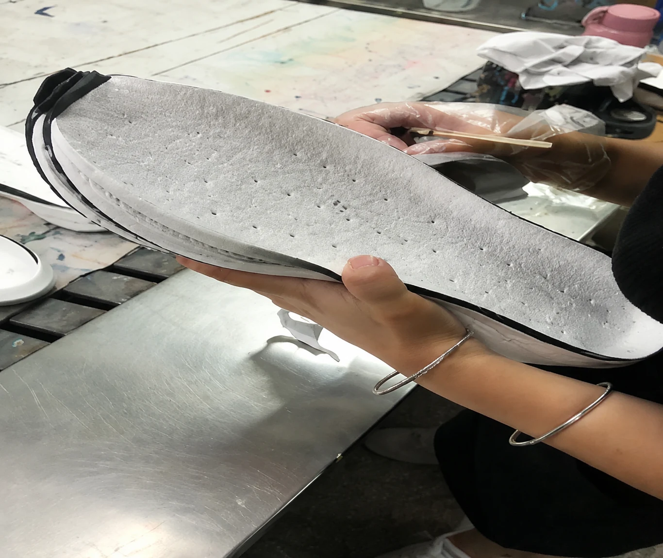 A footwear component being handled during surface preparation